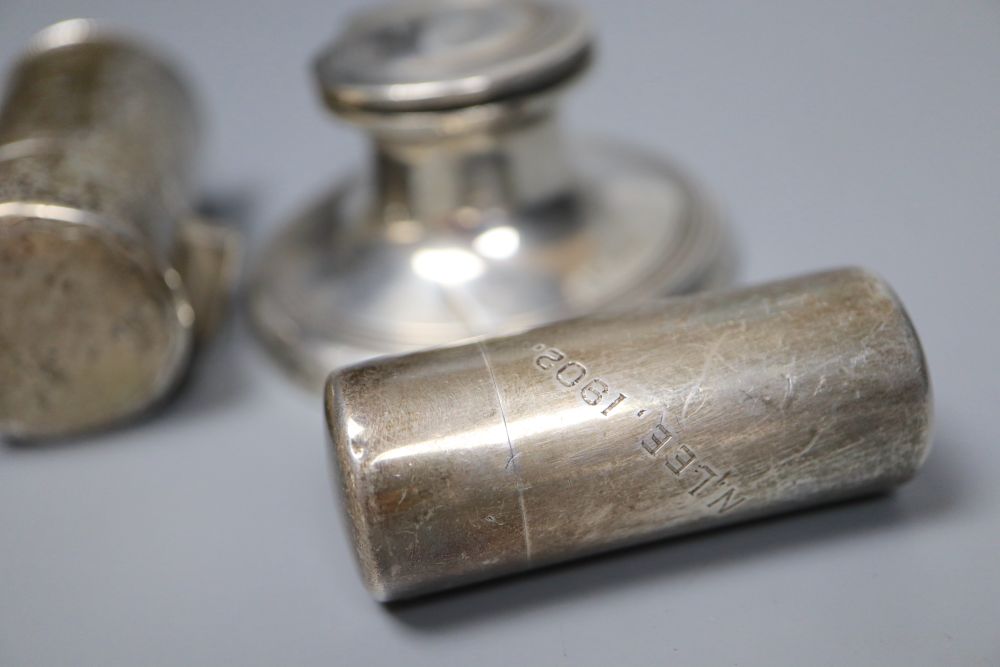 A silver capstan inkwell and two silver-cased cylindrical scent bottles